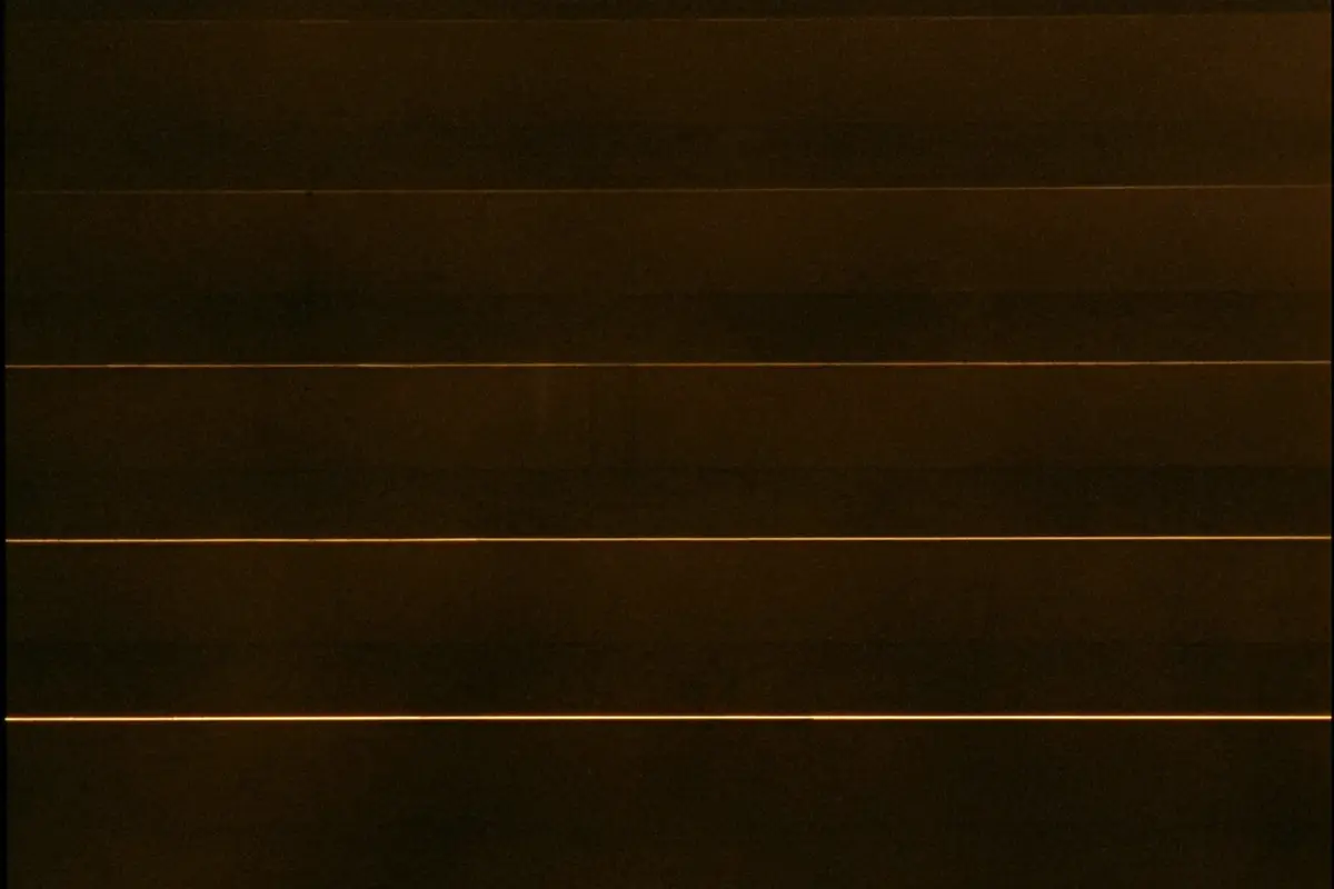 Ordered rows of thin amber light lines in darkness